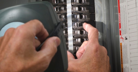 man checking circuit breakers