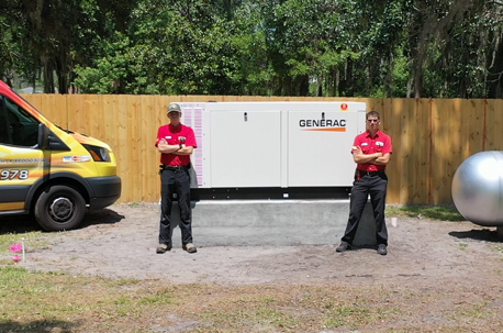 Small Jobs Electric technician standing next to a newly installed residential generator.